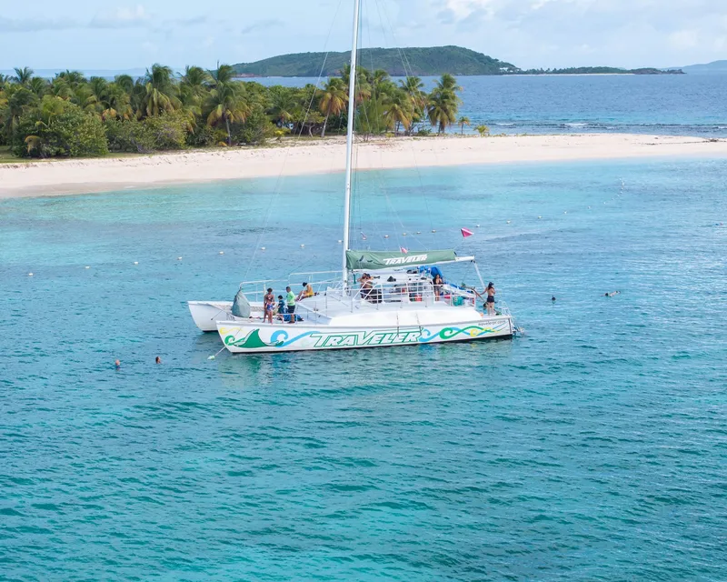 A catamaran anchored off Icacos Island on a snorkeling tour from Fajardo with guests swimming in clear water